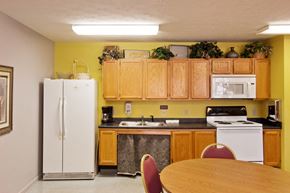 Cincinnati apartment for rent - a kitchen with white appliances and wooden cabinets and a table