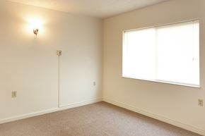 Cincinnati apartment for rent - a bedroom with a large window and white walls