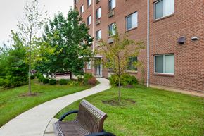 Cincinnati apartment for rent - a park bench in front of a brick building