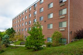 Cincinnati apartment for rent - a brick building with trees and grass in front of it
