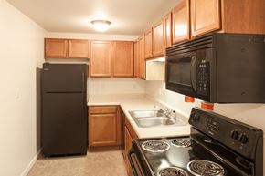 Indianapolis apartment for rent - a kitchen with black appliances and wood cabinets