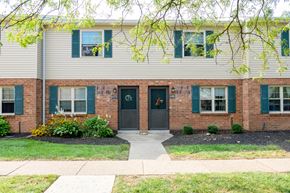 Batavia apartment for rent - front view of a white house with blue doors and a sidewalk