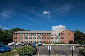 Xenia apartment for rent - a large brick building with cars in a parking lot