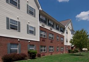 Cincinnati apartment for rent - a brick apartment building with white siding and a green lawn