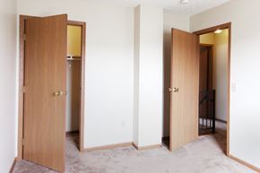 Cambridge apartment for rent - a bedroom with three doors and a hallway to a closet