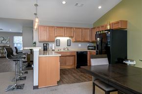 Columbus apartment for rent - a kitchen and dining room with wooden cabinets and a black refrigerator