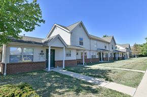 Logansport apartment for rent - a row of white houses with a sidewalk and grass