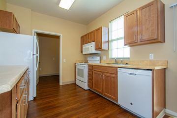 Columbus apartment for rent - a kitchen with wood flooring and wooden cabinets and white appliances