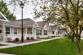 Dayton apartment for rent - a row of white houses with trees and a sidewalk