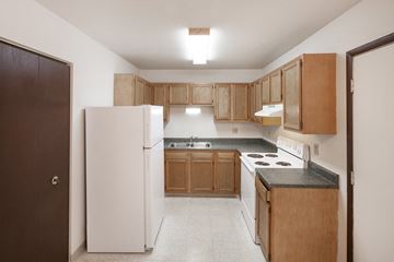 Delaware apartment for rent - a kitchen with wood cabinets and white appliances and a refrigerator