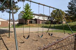 Dayton apartment for rent - a swing set in a playground with a house in the background