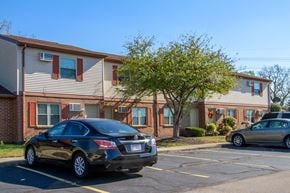 Miamisburg apartment for rent - an apartment building with cars parked in a parking lot