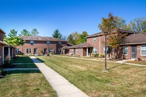 Dayton apartment for rent - a row of brick houses with a sidewalk and grass