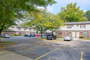 Urbana apartment for rent - a parking lot with cars in front of an apartment building