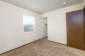 Moraine apartment for rent - a bedroom with a door and a window and a carpeted floor