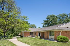 Peoria apartment for rent - a brick house with a lawn and trees