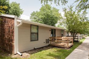 Mitchell apartment for rent - the exterior of a mobile home with a deck and trees