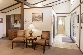 Mitchell apartment for rent - a hallway with two chairs and a table with a lamp   and a kitchen