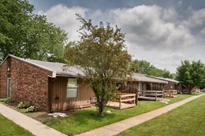 Paoli apartment for rent - a small brown house with a porch and a tree in front of it