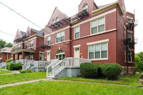 Cincinnati apartment for rent - a red brick apartment building with a white staircase