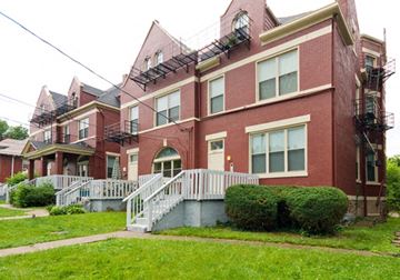 Cincinnati apartment for rent - a red brick apartment building with a white staircase