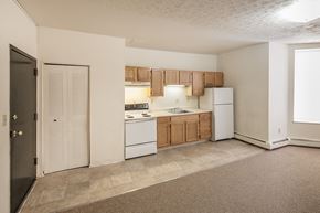 Cincinnati apartment for rent - an empty kitchen with white appliances and wooden cabinets