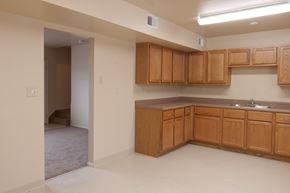Cincinnati apartment for rent - an empty kitchen with wooden cabinets and a sink