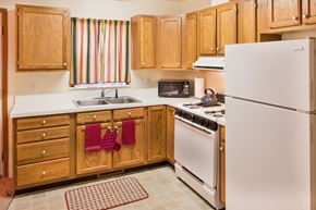 Cincinnati apartment for rent - a kitchen with white appliances and wooden cabinets