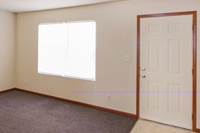 Cincinnati apartment for rent - an empty living room with a white door and a window