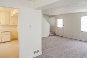 Cincinnati apartment for rent - an empty living room and kitchen with a door to a staircase