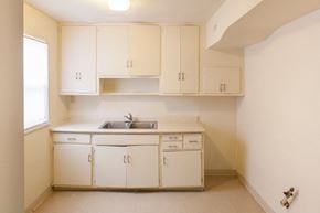 Cincinnati apartment for rent - an empty kitchen with white cabinets and a sink