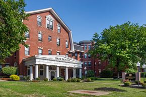 Cincinnati apartment for rent - a large brick building with a lawn and trees