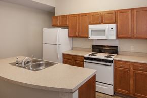 Covington apartment for rent - a kitchen with white appliances and wooden cabinets