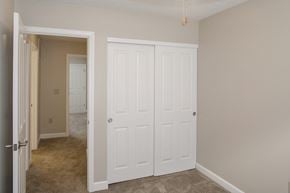 Independence apartment for rent - a bedroom with two closets and a door to a hallway