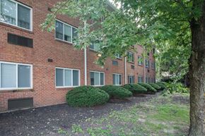 Ludlow apartment for rent - the exterior of a brick apartment building with trees and bushes