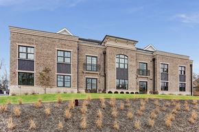 Bernardsville apartment for rent - the front of a brick building with windows and a grass field