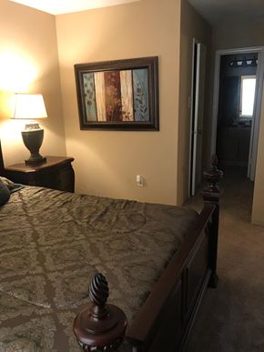 Houston apartment for rent - a bedroom with a large bed and a painting on the wall