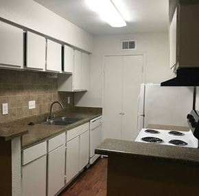 Houston apartment for rent - a kitchen with white cabinets and a stove and sink