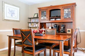 Houston apartment for rent - a dining area with a table and chairs and a hutch with a television