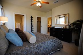 Houston apartment for rent - a bedroom with a large bed and a ceiling fan