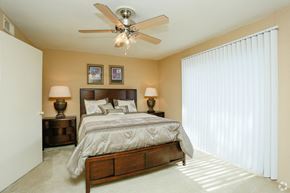 Houston apartment for rent - a bedroom with a large bed and a ceiling fan