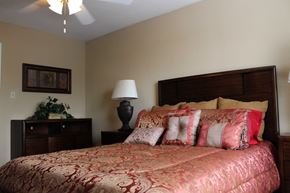 Houston apartment for rent - a bedroom with a bed and a dresser and a ceiling fan