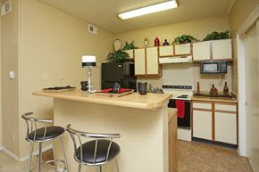 Dallas apartment for rent - a kitchen with a breakfast bar and a counter top with two stools
