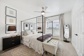 Plano apartment for rent - A bedroom with a four poster bed and a ceiling fan.