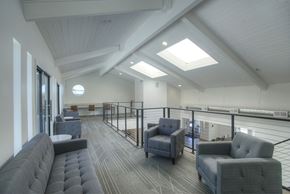 Phoenix apartment for rent - A spacious room with grey furniture and a skylight.