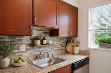 Alexandria apartment for rent - A kitchen with brown cabinets and a stone backsplash.
