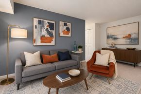 Alexandria apartment for rent - A living room with a grey couch, a red chair, and a coffee table.