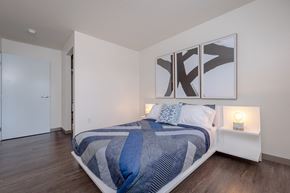 Cleveland apartment for rent - Bedroom in an apartment furnished with a queen-size bed, two nightstands, vinyl flooring, and high ceiling