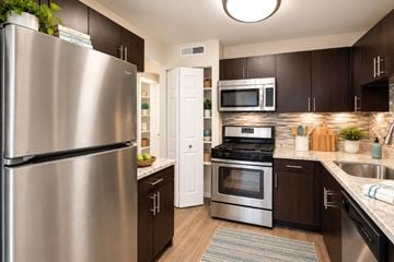 Fairfax apartment for rent - A modern kitchen with dark brown cabinets and stainless steel appliances.