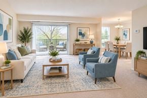 Fairfax apartment for rent - A living room with a white couch, blue chairs, and a wooden coffee table.